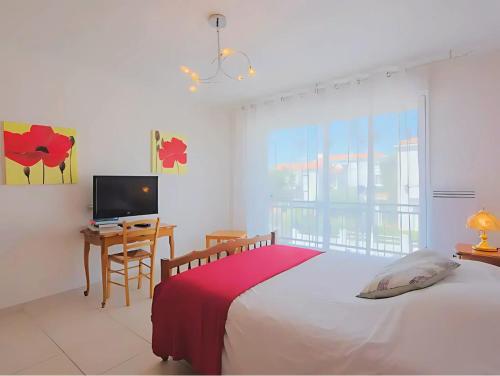 une chambre avec un lit, un bureau et une télévision dans l'établissement Maison de vacances à 500m de la plage avec stationnement, à Les Sables-dʼOlonne