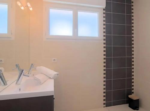 une salle de bain avec un lavabo et un miroir dans l'établissement Maison de vacances à 500m de la plage avec stationnement, à Les Sables-dʼOlonne