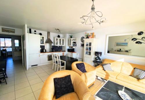 un salon avec deux canapés et une cuisine dans l'établissement HELIAS appartement face mer remblai LS0477, à Les Sables-dʼOlonne