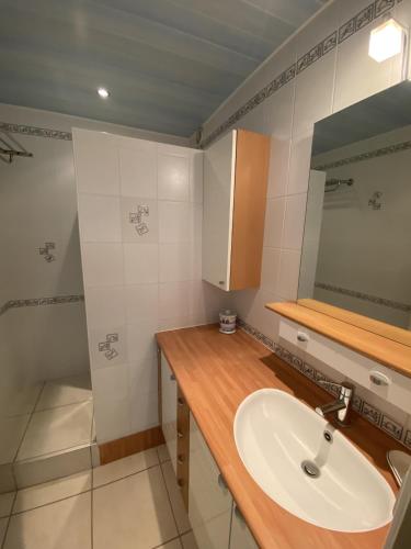 une salle de bain avec un lavabo et un miroir dans l'établissement HELIAS appartement face mer remblai LS0477, à Les Sables-dʼOlonne