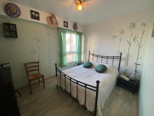 - une chambre avec un lit doté d'oreillers verts dans l'établissement HELIAS appartement face mer remblai LS0477, à Les Sables-dʼOlonne