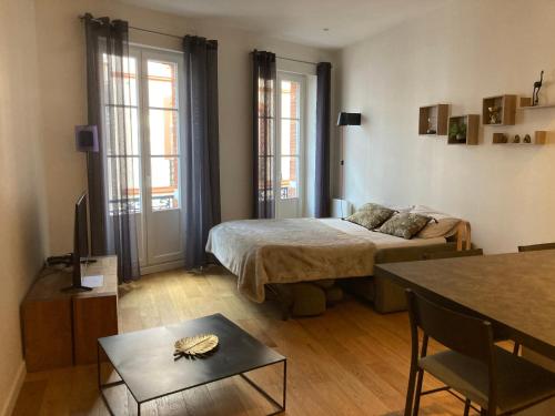 une chambre avec un lit et une table dans une pièce dans l'établissement La halle aux grains, à Toulouse