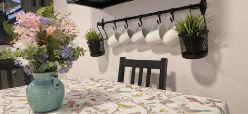 a table with a vase of flowers on a table at Refurbed Modern & Stylish 3BD - Garden Pets OK in Dublin