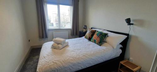 a bedroom with a bed with two towels on it at Refurbed Modern & Stylish 3BD - Garden Pets OK in Dublin