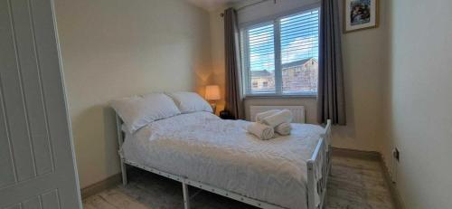 a small bedroom with a bed and a window at Refurbed Modern & Stylish 3BD - Garden Pets OK in Dublin