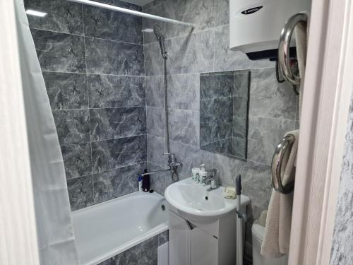 a bathroom with a sink and a toilet and a bath tub at Сдаётся однокомнатная квартира Люкс возле озера. in Balqash