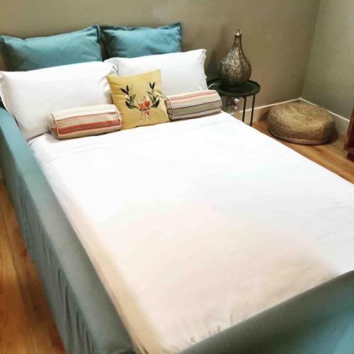 a large bed with white sheets and pillows at The Cowshed Cottage on The Greenway in Dungarvan