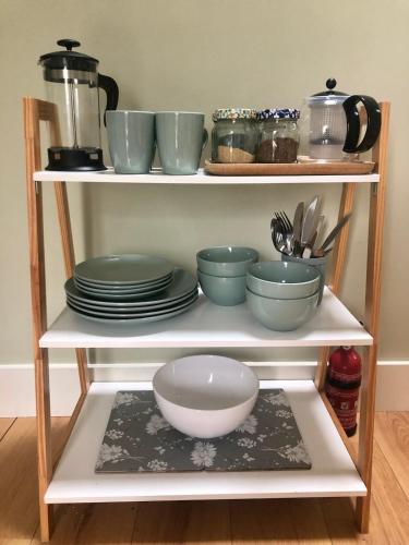 a shelf with plates and bowls on it at The Cowshed Cottage on The Greenway in Dungarvan