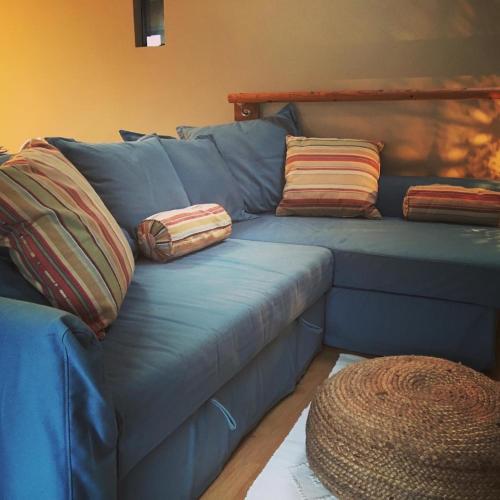 a blue couch with pillows on it in a living room at The Cowshed Cottage on The Greenway in Dungarvan