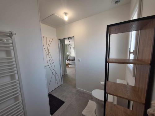 La salle de bains est pourvue de toilettes et d'une porte en verre. dans l'établissement Appartement 5A - Saintes, à Saintes