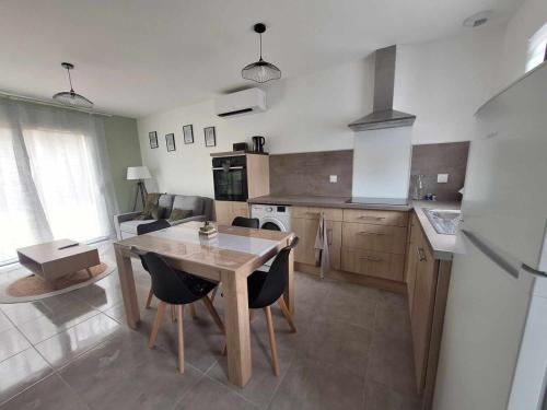 une cuisine avec une table et des chaises dans une cuisine dans l'établissement Appartement 5A - Saintes, à Saintes