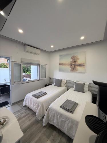a bedroom with two beds and a flat screen tv at Discovery Tavira in Tavira