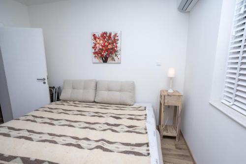 a white room with a bed with a painting on the wall at Complex Saint-George spacious apartment 2 bedrooms 2 bathrooms, great seaview in Kavarna