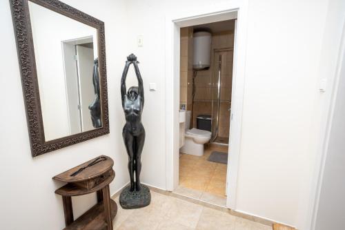 a bathroom with a statue and a mirror and a toilet at Complex Saint-George spacious apartment 2 bedrooms 2 bathrooms, great seaview in Kavarna