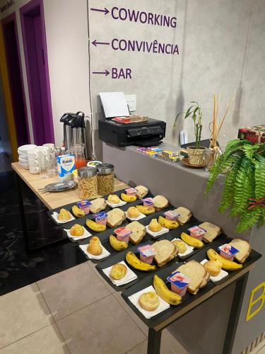 een tafel vol met verschillende soorten sandwiches en bananen bij Belô Hostel in Belo Horizonte