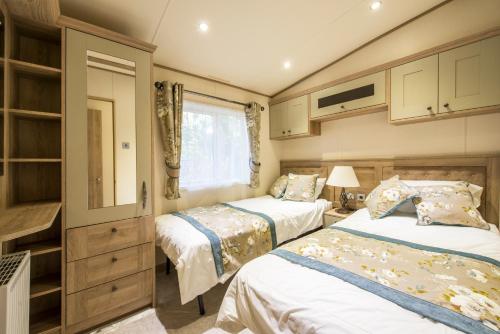 two beds in a small room with a window at St. Ives Holiday Village in St Ives