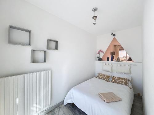 - une chambre avec des murs blancs et un lit blanc dans l'établissement La Salangane, à Cannes