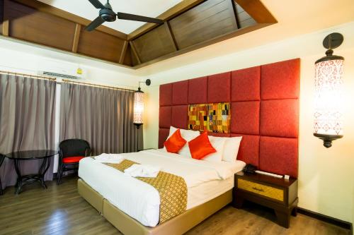 a bedroom with a bed and a red headboard at Nak Nakara Hotel in Chiang Rai