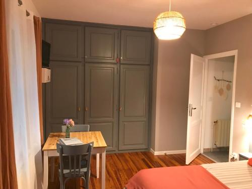 une salle à manger avec une table et un placard dans l'établissement Chambre d'hôtes 'Sous le magnolia', à Oloron-Sainte-Marie