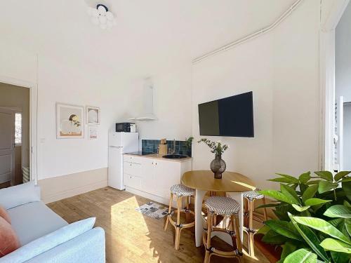 ein Wohnzimmer mit Tisch und Küche in der Unterkunft Vesle- Hyper Centre - 2 Chambres in Reims