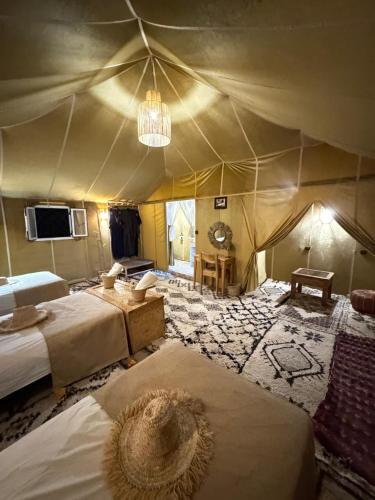 a large room with two beds in a tent at Desert camp camel & sandboarding in Merzouga