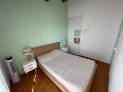 une petite chambre avec un lit blanc et une lampe dans l'établissement Résidence CAP SOLEIL, piscines, tennis..., à Saint-Mandrier-sur-Mer