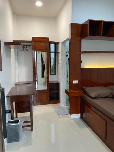 a bedroom with a bed and a desk and a mirror at The Homey Coliving Lhokseumawe in Hago
