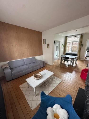 un salon avec un canapé et une table dans l'établissement La Malouine Dunkerquoise HomyNest, à Dunkerque