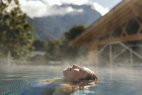 a woman floating in the water in the water at Feelfree Nature Resort in Oetz