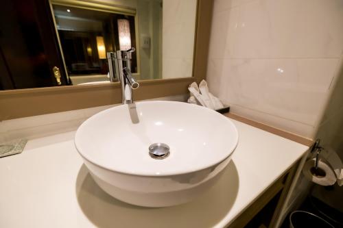 a white sink in a bathroom with a mirror at Nak Nakara Hotel in Chiang Rai