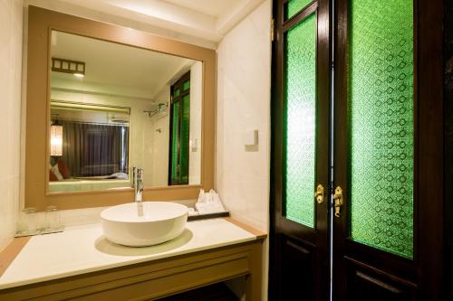 a bathroom with a sink and a mirror at Nak Nakara Hotel in Chiang Rai