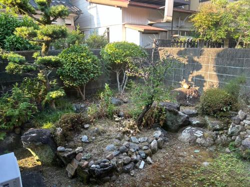 a backyard with a garden with rocks and a dog at Shingu Guest House SOU 別館 in Shingu