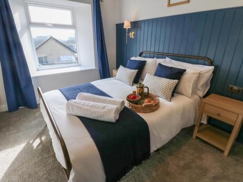 a bedroom with a bed with a bowl of fruit on it at Hollywood Cottage in Barnard Castle