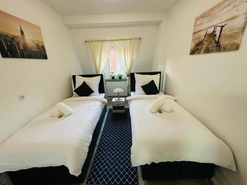 two twin beds in a room with a window at FEWO- Rafaelo2 in Marsberg