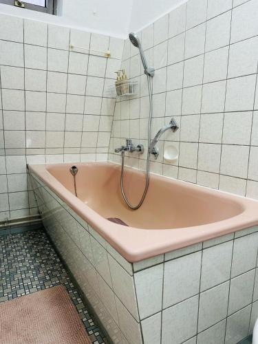 a pink bath tub with a shower in a bathroom at FEWO- Rafaelo2 in Marsberg