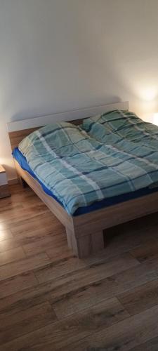 a bed sitting on a wooden floor in a room at grünes Glück in Witten