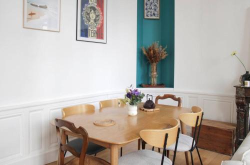 une salle à manger avec une table et des chaises en bois dans l'établissement Duplex de charme au cœur du 2ème, à Paris