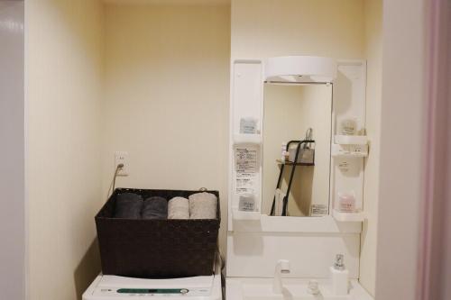 a bathroom with a toilet and a sink and a mirror at 有朋ハウス 301 in Osaka