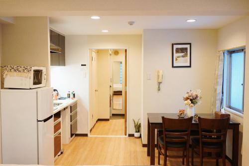 a kitchen and dining room with a table and a refrigerator at 有朋ハウス 301 in Osaka