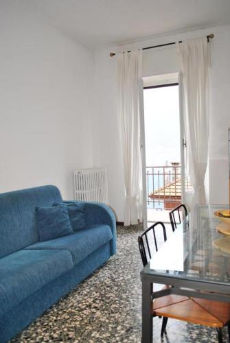 a living room with a blue couch and a glass table at The Family Houses - Apartments with Balcony and Lake View in Colonno