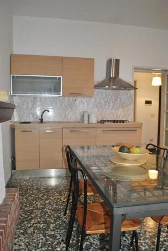 a kitchen with a table with a bowl of fruit on it at The Family Houses - Apartments with Balcony and Lake View in Colonno