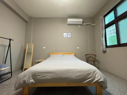 a bedroom with a bed and a window at Hello Guesthouse in Lugang