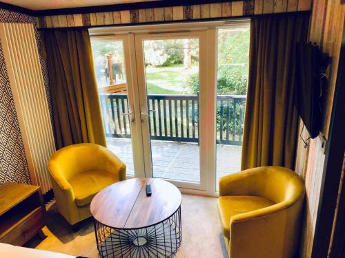 a living room with two chairs and a coffee table at Sandy Balls Holiday Park Pet Friendly Lodge in Fordingbridge
