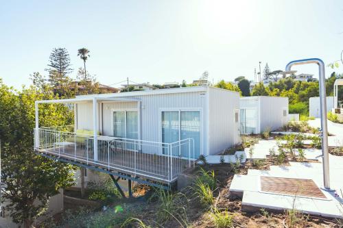 a white house with a porch and a deck at Costa del Sol Glamping Village in Fuengirola