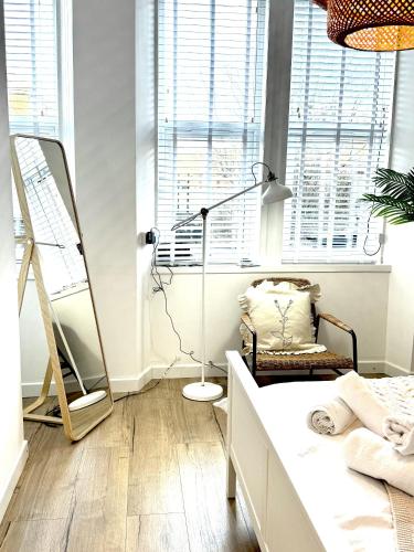a bedroom with a bed and a lamp and a chair at Castlegreen Lux Apartment in Dumbarton