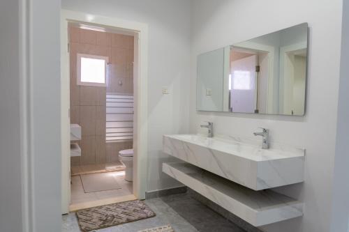 a white bathroom with a sink and a mirror at The view apartment 1 in Al Baha