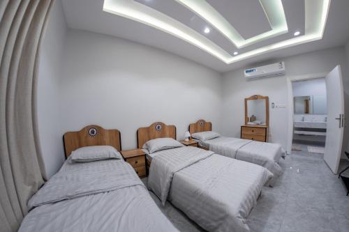 three beds in a room with a skylight at The view apartment 1 in Al Baha