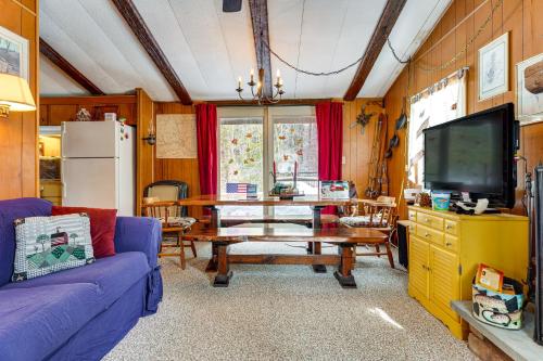 a living room with a table and a tv at Hike, Ski and Unwind Cabin with Deck in Chester! in Chester