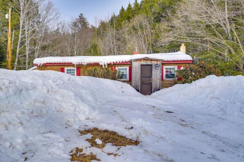 a house in the snow with a pile of snow at Hike, Ski and Unwind Cabin with Deck in Chester! in Chester