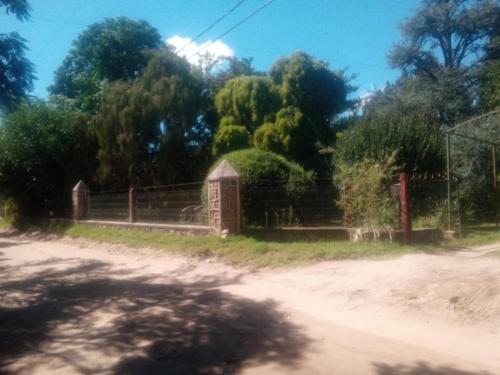 a fence on the side of a dirt road at Cabaña en quinta la aurora in Mina Clavero